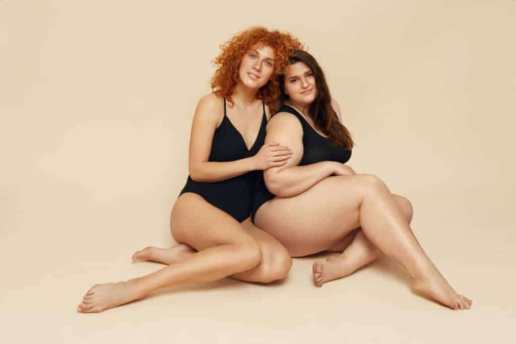 two women in leotards sitting on the ground