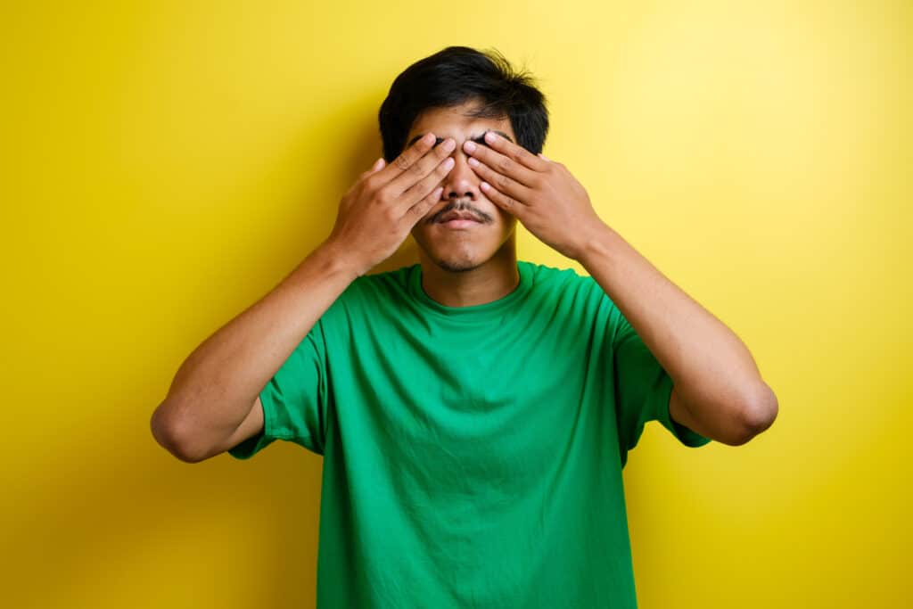 teen boy covering eyes