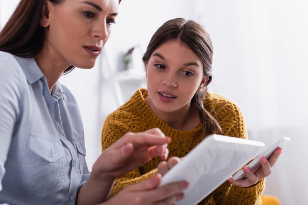 mother and daughter looking at tech together