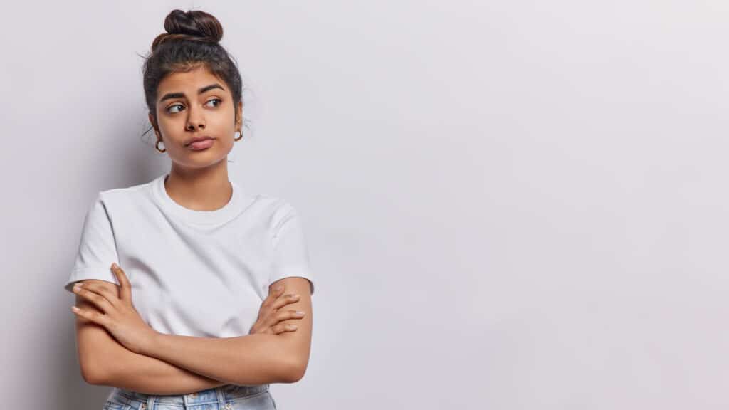 teen girl with arms folded looking to the side