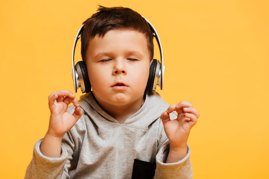 little boy feeling zen listening to music in headphones