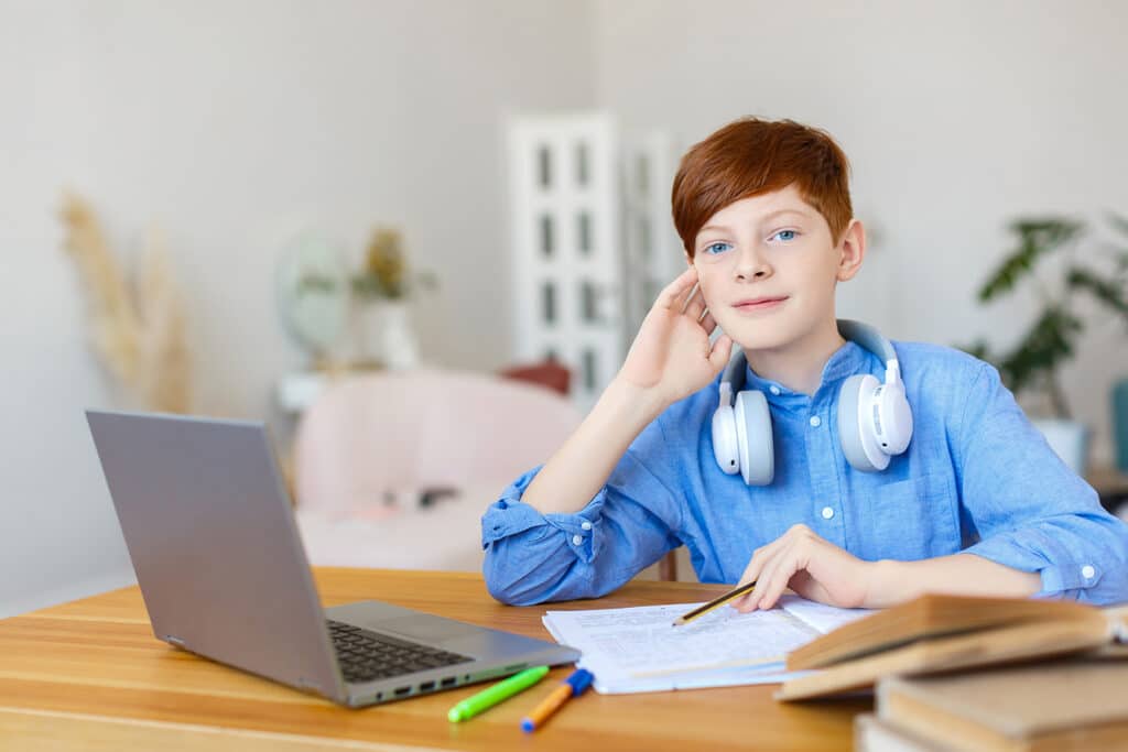 redheaded boy at laptop doing homework