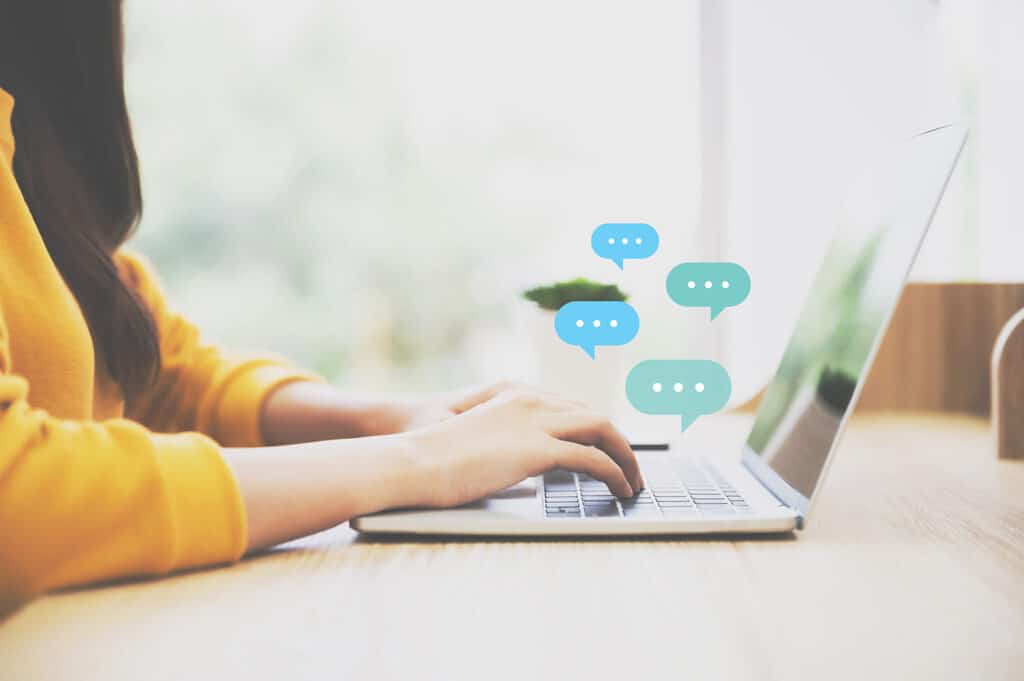 girl typing on laptop with chat bubbles above