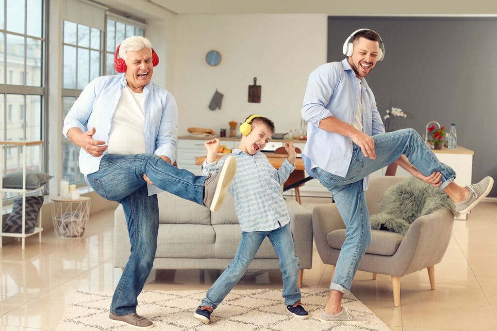 Grandpa, father, and son playing air guitar listening to headphones