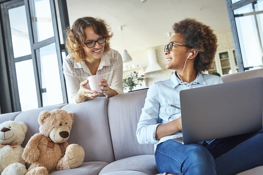 daughter on laptop smiling at her mom