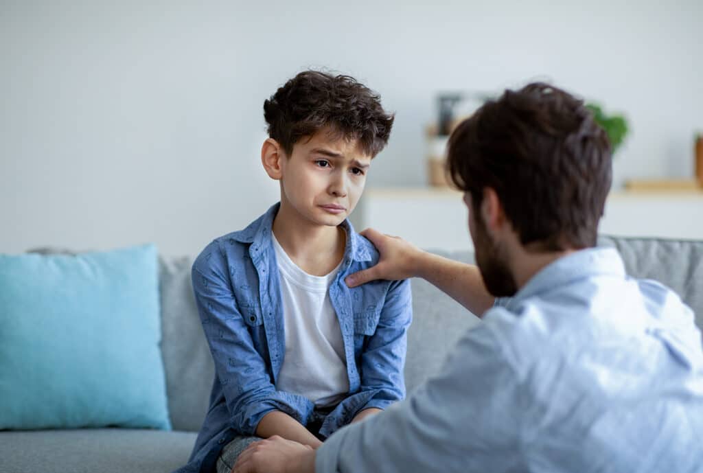 father comforting upset son