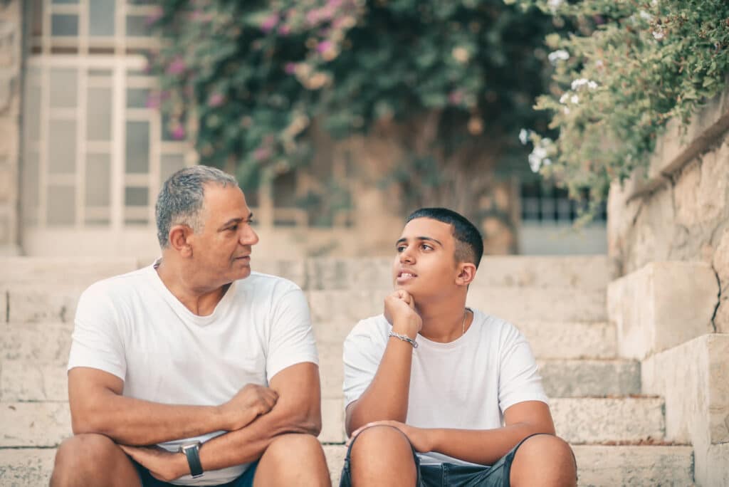 father and son chatting on stone steps