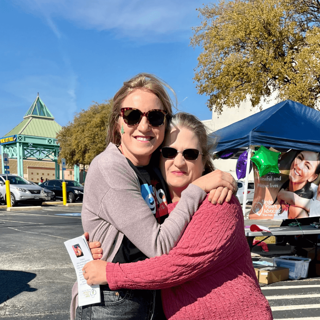 Two ladies embracing at Single Parent Advocate Event